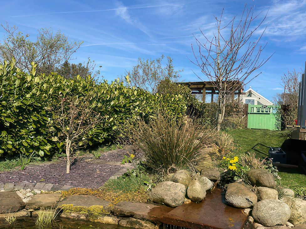 A garden with a pond and plants at How Hill Farm Cottage in Greystoke