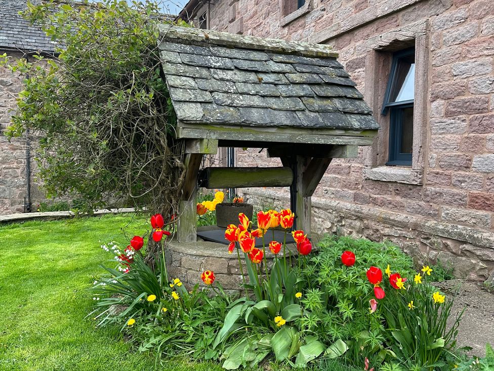 A well surrounded by flowers at How Hill Farm Cottage in Greystoke