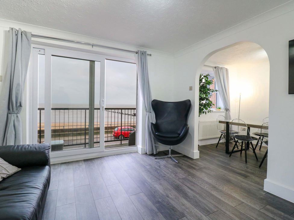 A living room with sofa and dining area at 79 Selsey Avenue