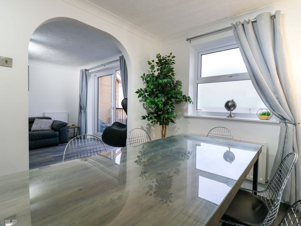 A dining room with a table and chairs at 79 Selsey Avenue