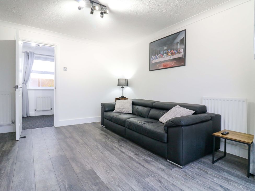 A living room with a sofa and lamp at 79 Selsey Avenue