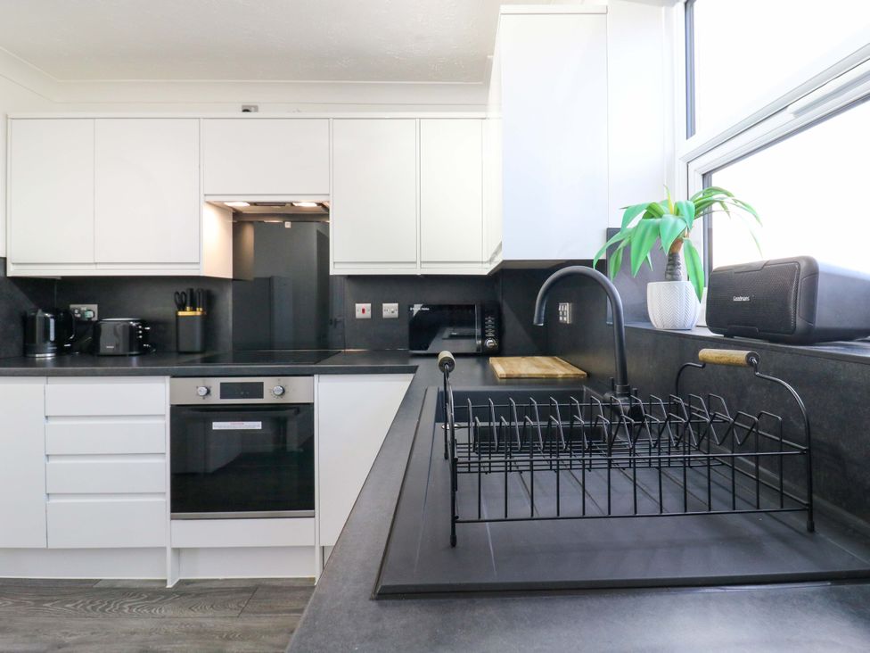 A kitchen with a sink, oven, and dish rack at 79 Selsey Avenue