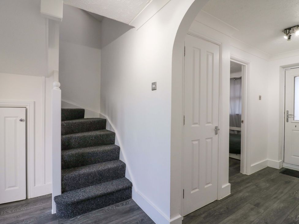 A hallway with stairs and doors at 79 Selsey Avenue