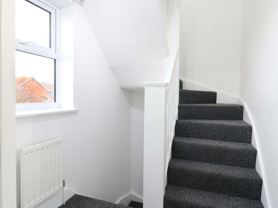 A staircase with a window and radiator at 79 Selsey Avenue