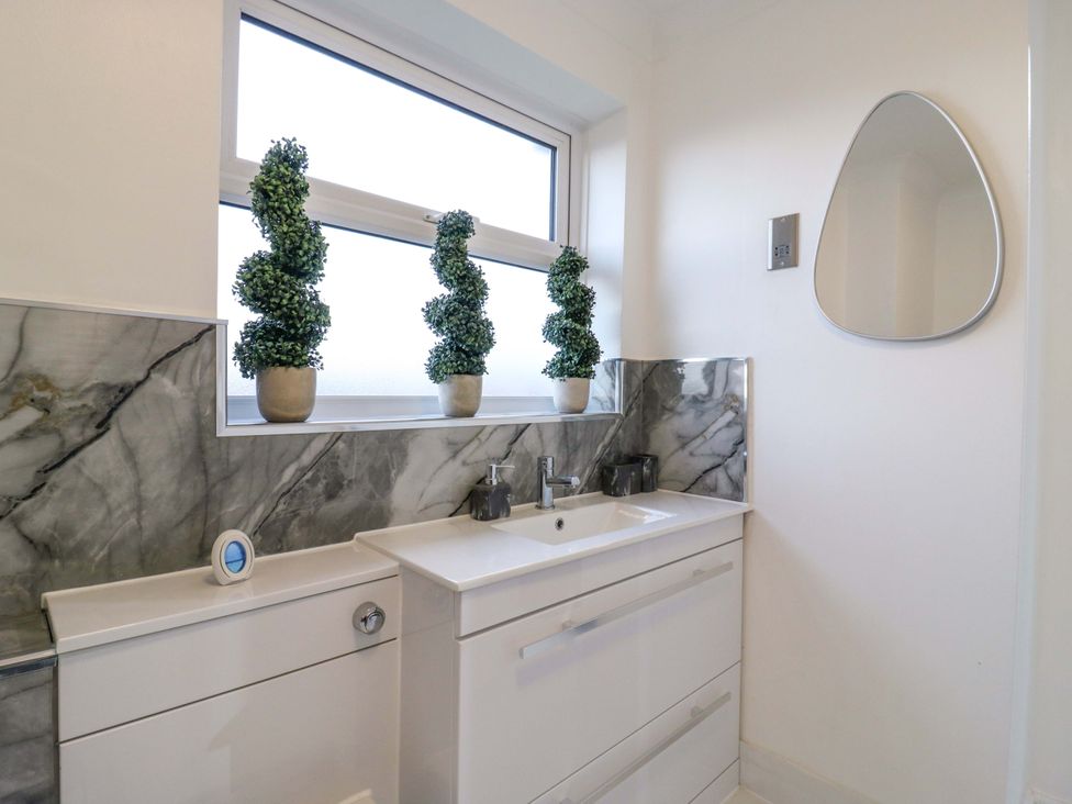 A bathroom with a sink and potted plants at 79 Selsey Avenue