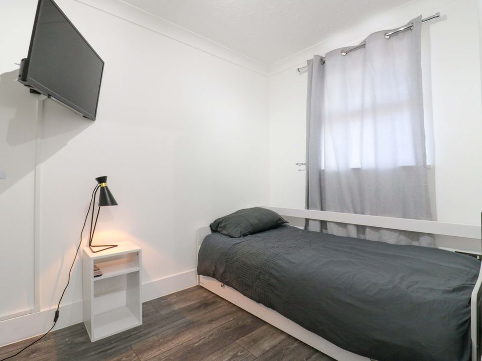 A bedroom with a bed, television, and lamp at 79 Selsey Avenue