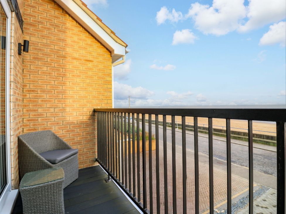 A balcony with a wicker chair overlooking the pavement at 79 Selsey Avenue