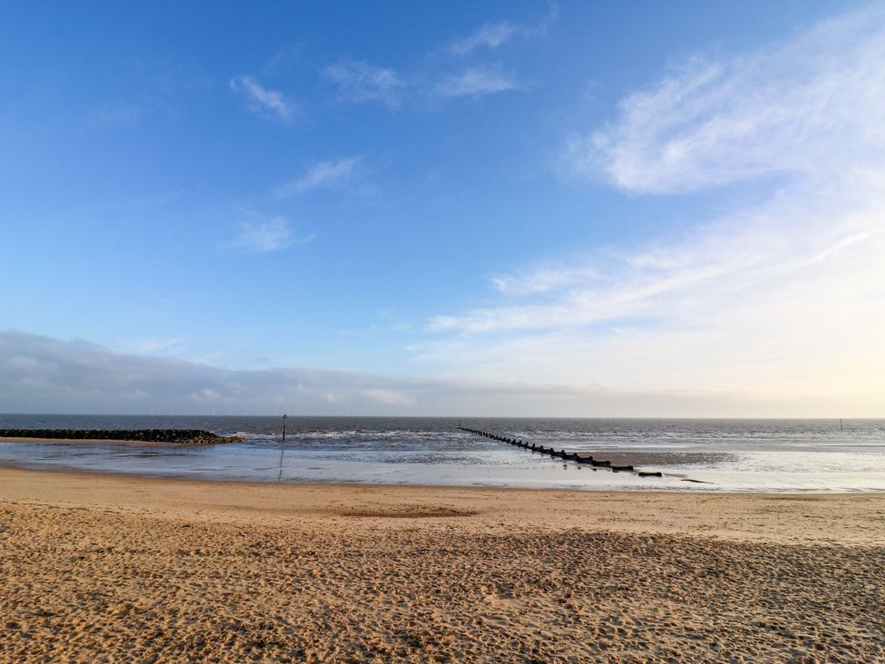 A beach with a pier extending into the water at 79 Selsey Avenue