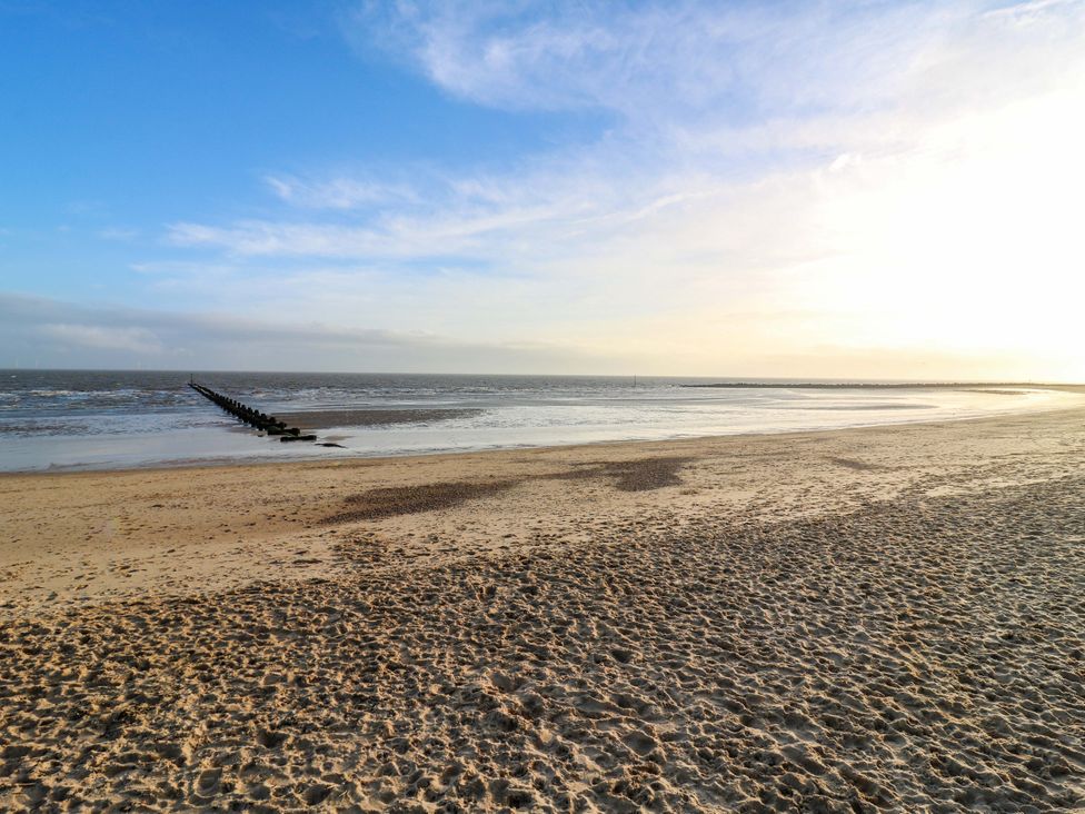 A beach with sand and a pier extending into the sea at 79 Selsey Avenue