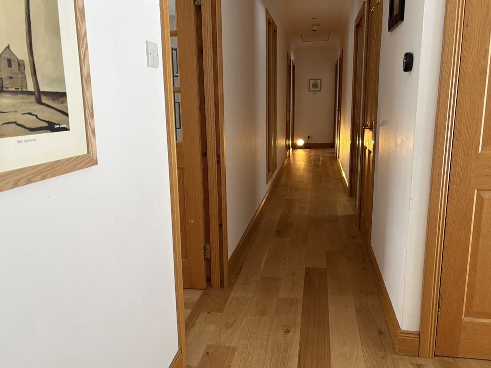 A hallway with wooden floors and doors at Mullingar in Pitlochry