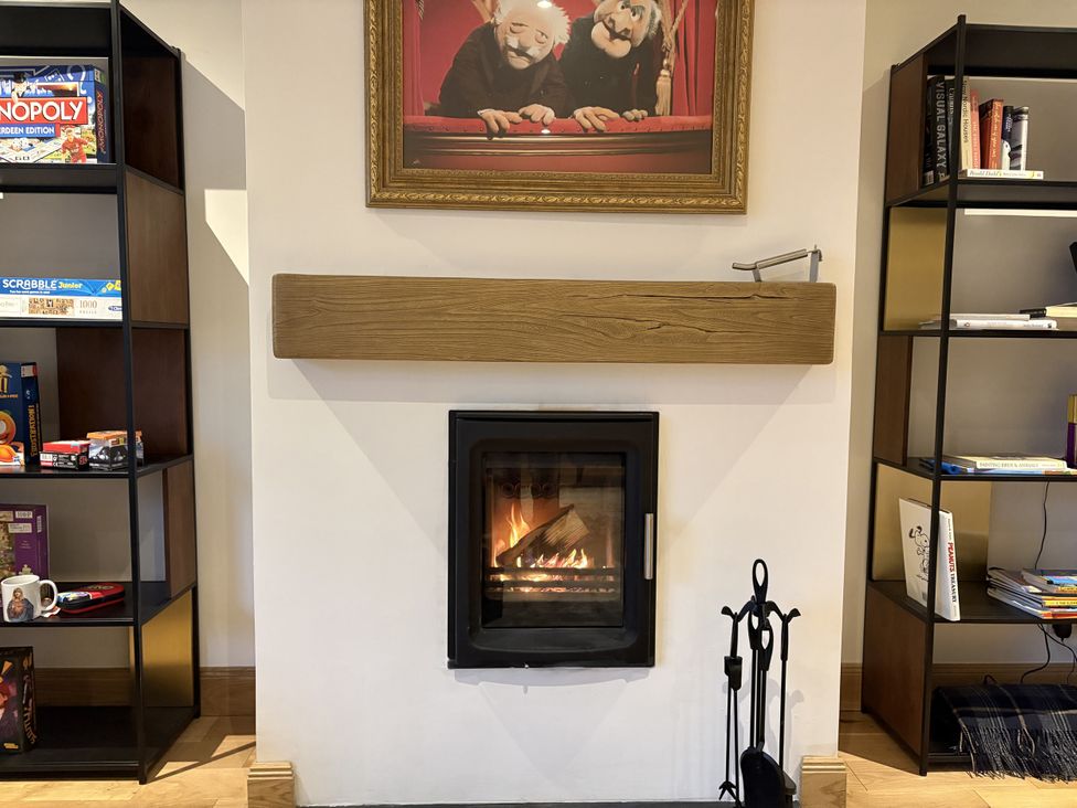 A living room with a fireplace and bookshelf at Mullingar in Pitlochry