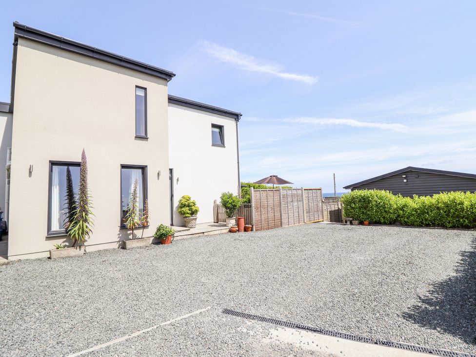 An exterior view of a house with plants and a gravel area at Bryn Mor in Benllech