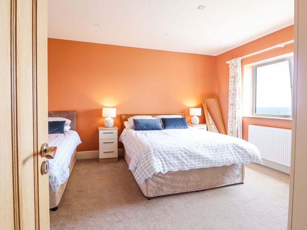 A bedroom with two beds and a window at Bryn Mor in Benllech