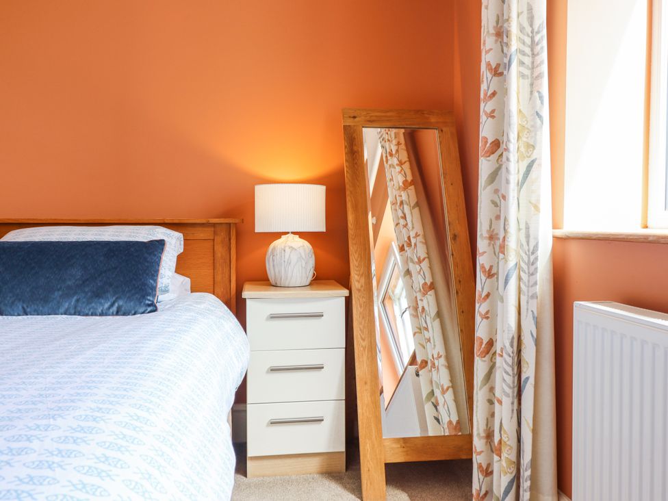 A bedroom with a bed and nightstand at Bryn Mor in Benllech