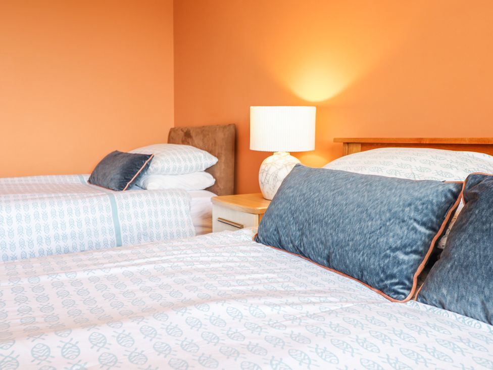 A bedroom with two beds and a lamp at Bryn Mor in Benllech