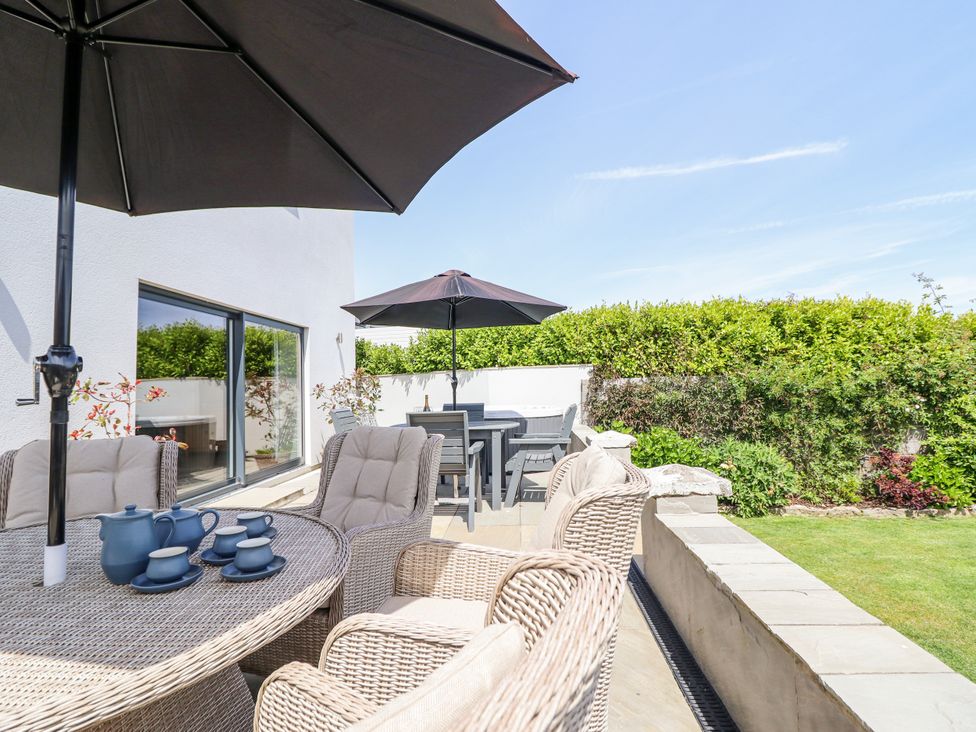 Outdoor seating area with a table and umbrellas at Bryn Mor in Benllech