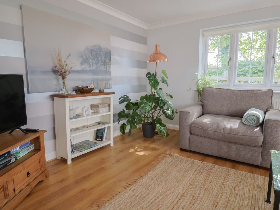 A living room with a plant and a chair at Rainbow View Churchstanton near Churchinford