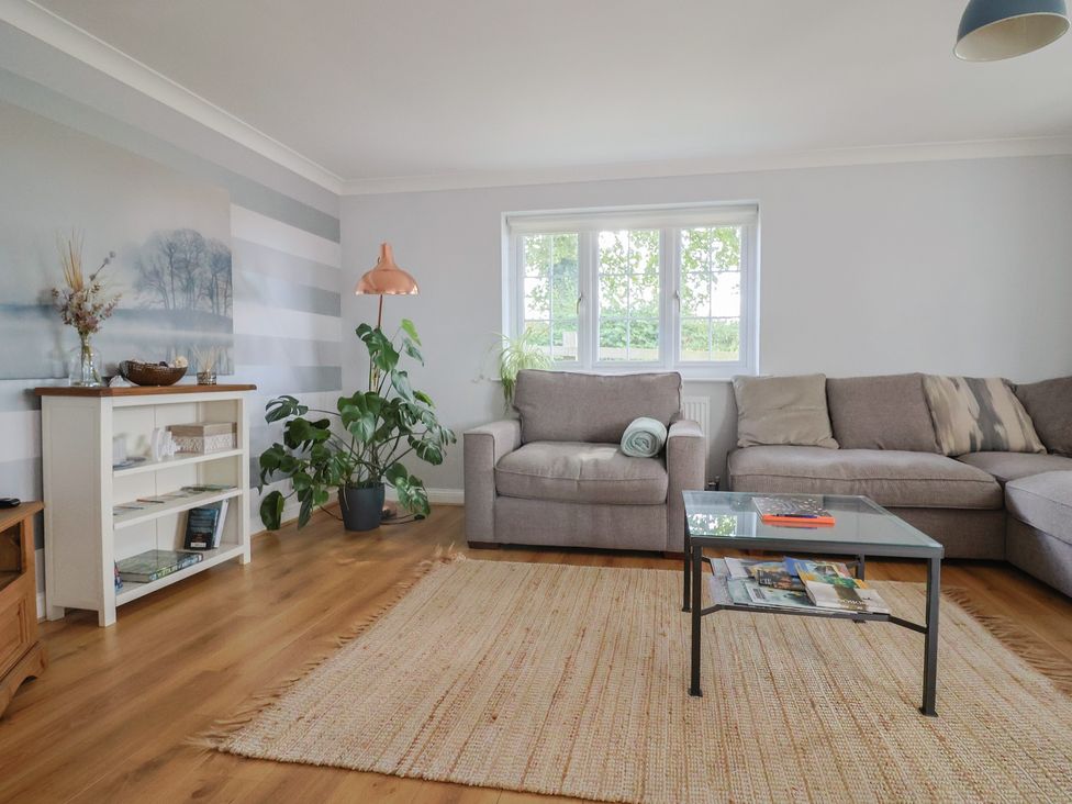 A living room with a couch, coffee table, and plants at Rainbow View, Churchstanton near Churchinford