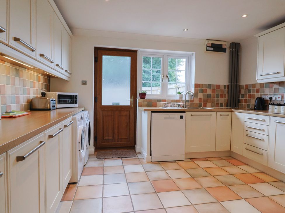 A kitchen featuring appliances and a door at Rainbow View in Churchstanton near Churchinford