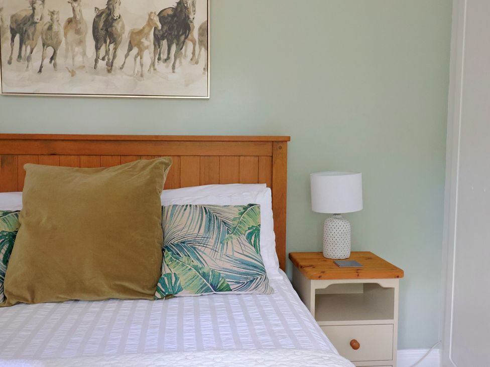 A bedroom with a bed and nightstand at Rainbow View Churchstanton near Churchinford