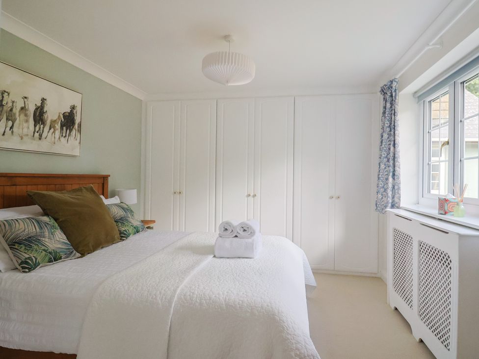 A bedroom with a bed and wardrobe at Rainbow View in Churchstanton near Churchinford