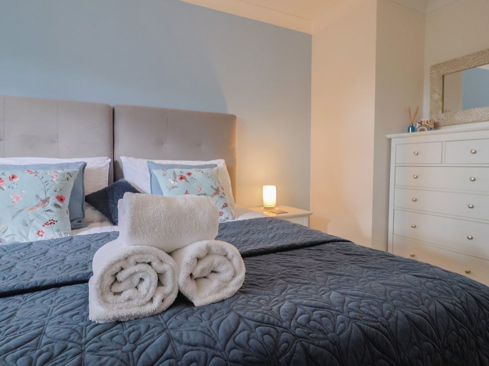 A bedroom with a bed and towels arranged at Rainbow View in Churchstanton near Churchinford