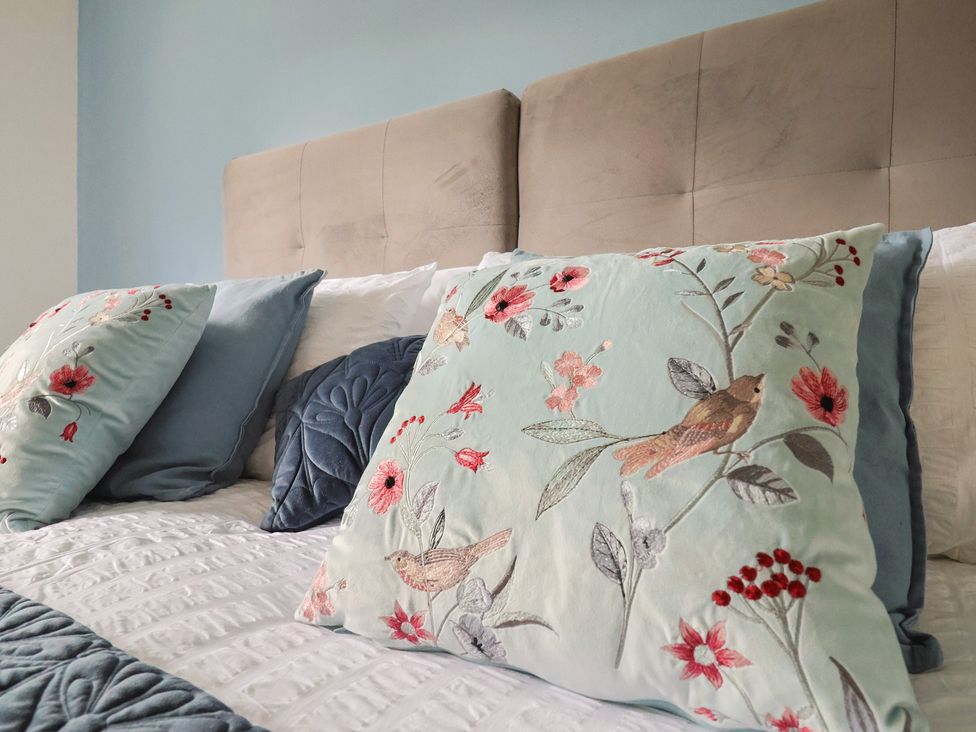A bedroom with decorative pillows on a bed at Rainbow View in Churchstanton near Churchinford
