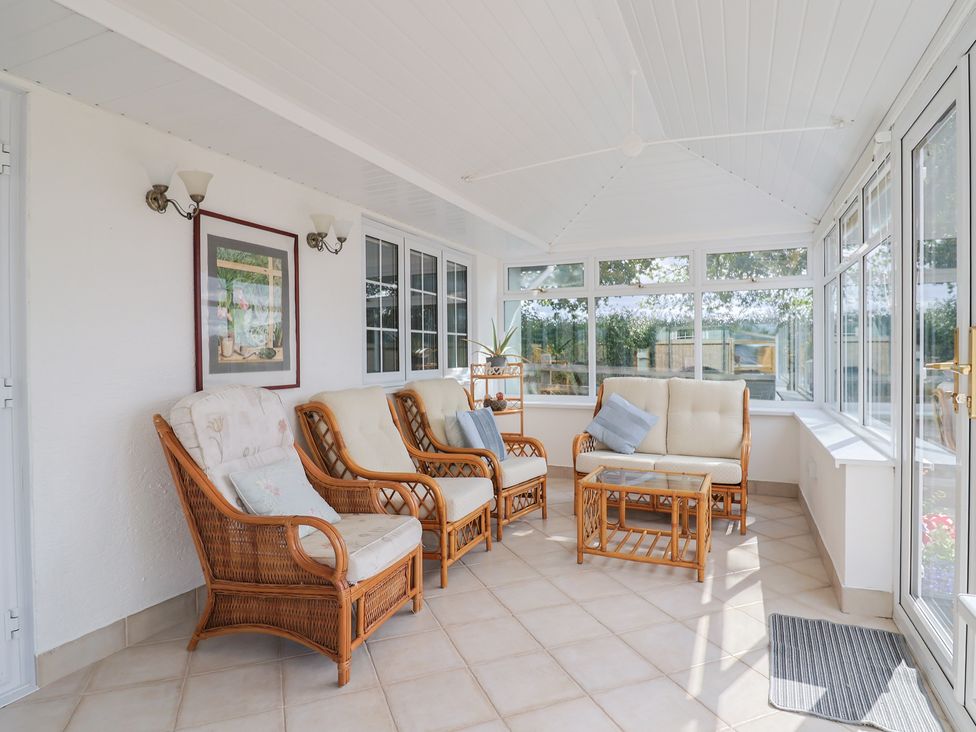 A conservatory with seating and a table at Rainbow View in Churchstanton near Churchinford