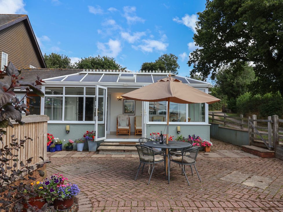 A garden with a table and chairs under an umbrella at Rainbow View in Churchstanton near Churchinford
