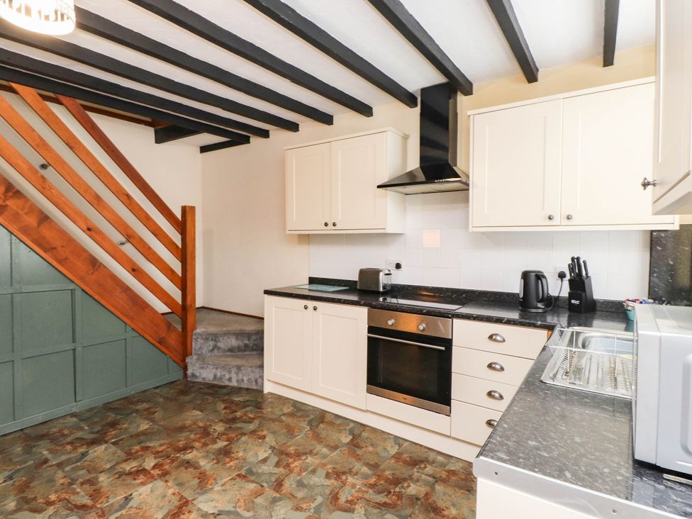 A kitchen with a staircase and countertop appliances at 11- 13 High Street