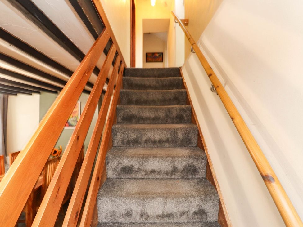 A staircase with wooden handrail and carpet at 11- 13 High Street
