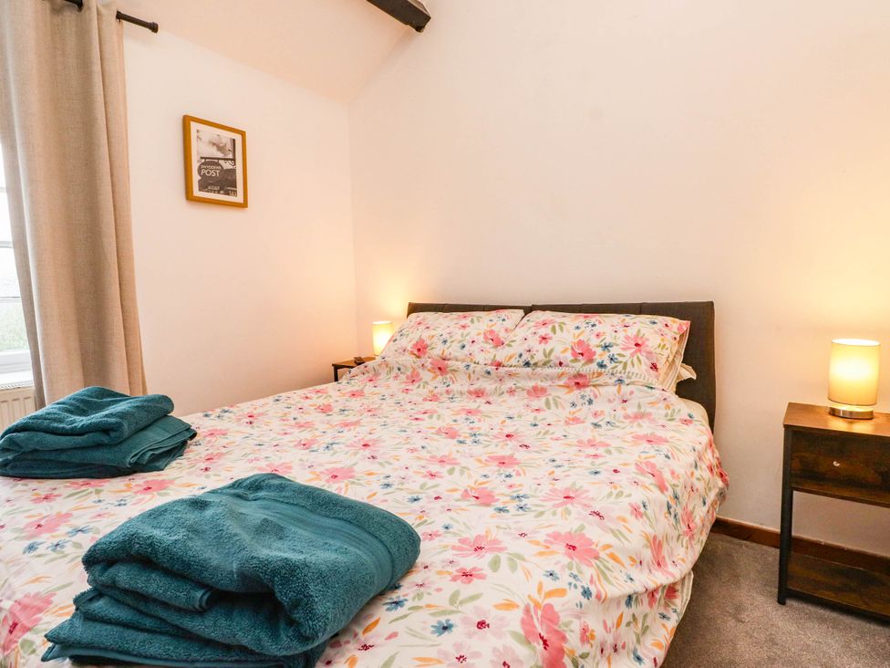 A bedroom with a bed and bedside table at 11- 13 High Street
