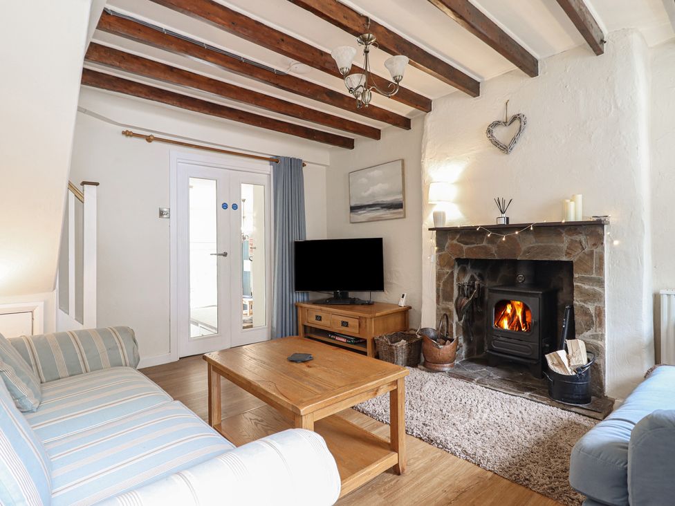 A living room with a fireplace and sofa at Riverside Cottage in Beddgelert