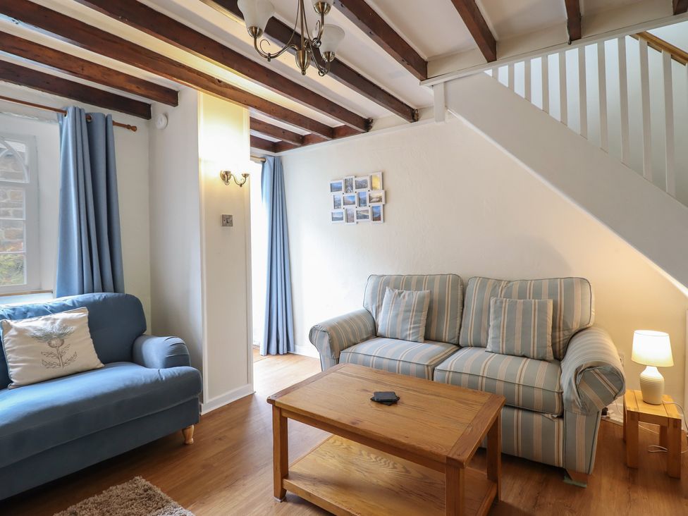 A living room with sofas and a coffee table at Riverside Cottage in Beddgelert