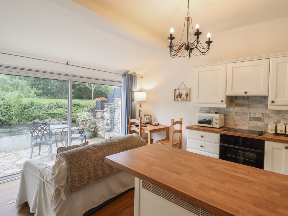 A kitchen with a sofa and table at Riverside Cottage in Beddgelert
