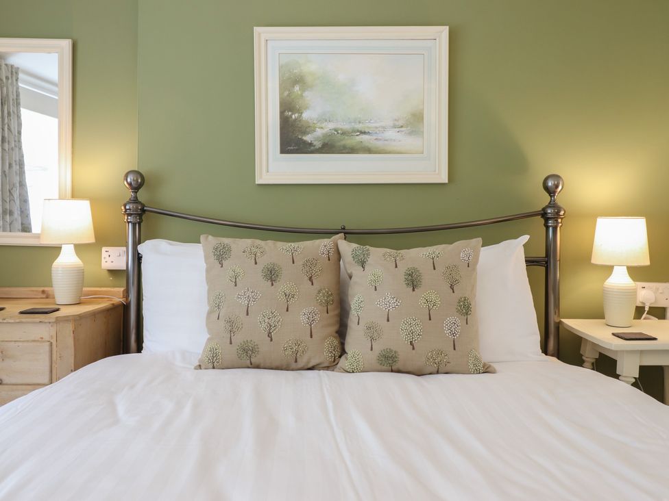 A bedroom with a bed and lamps at Riverside Cottage Beddgelert