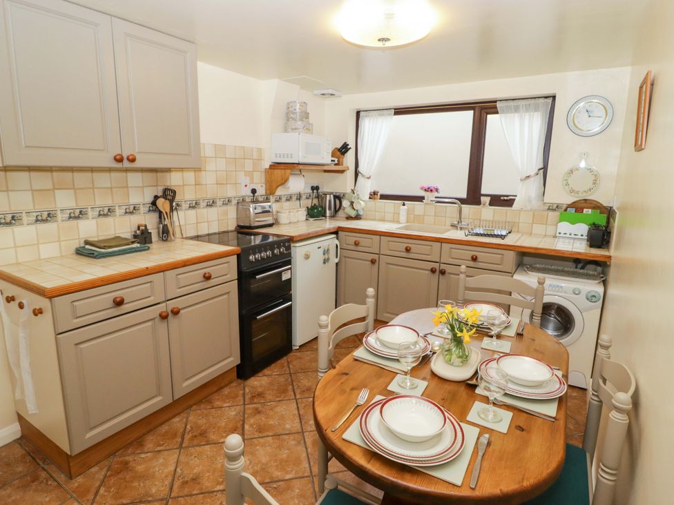 A kitchen with cabinets stove and dining table at Penn Lea in Penally
