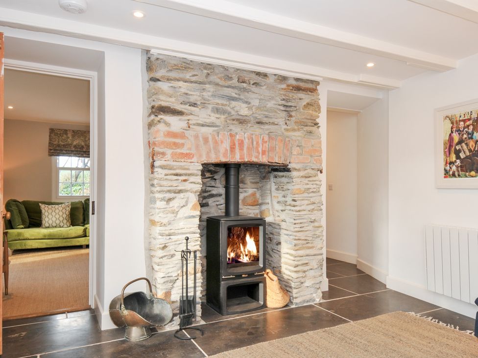 A living room with a stone fireplace and wood stove at Mermaid Cottage in Port Isaac