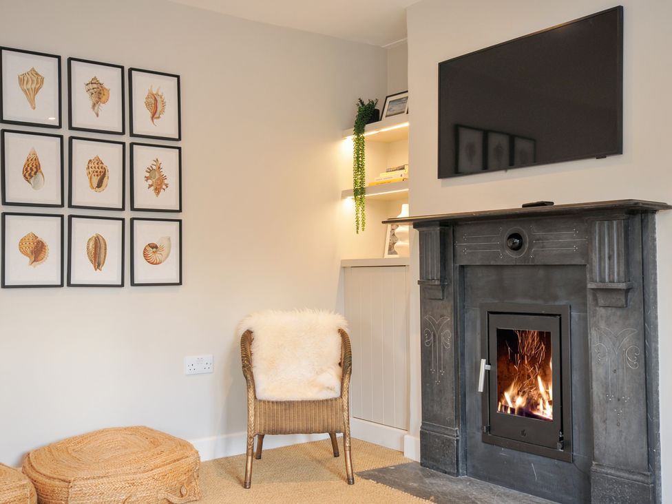 A living room with a fireplace and a television at Mermaid Cottage in Port Isaac