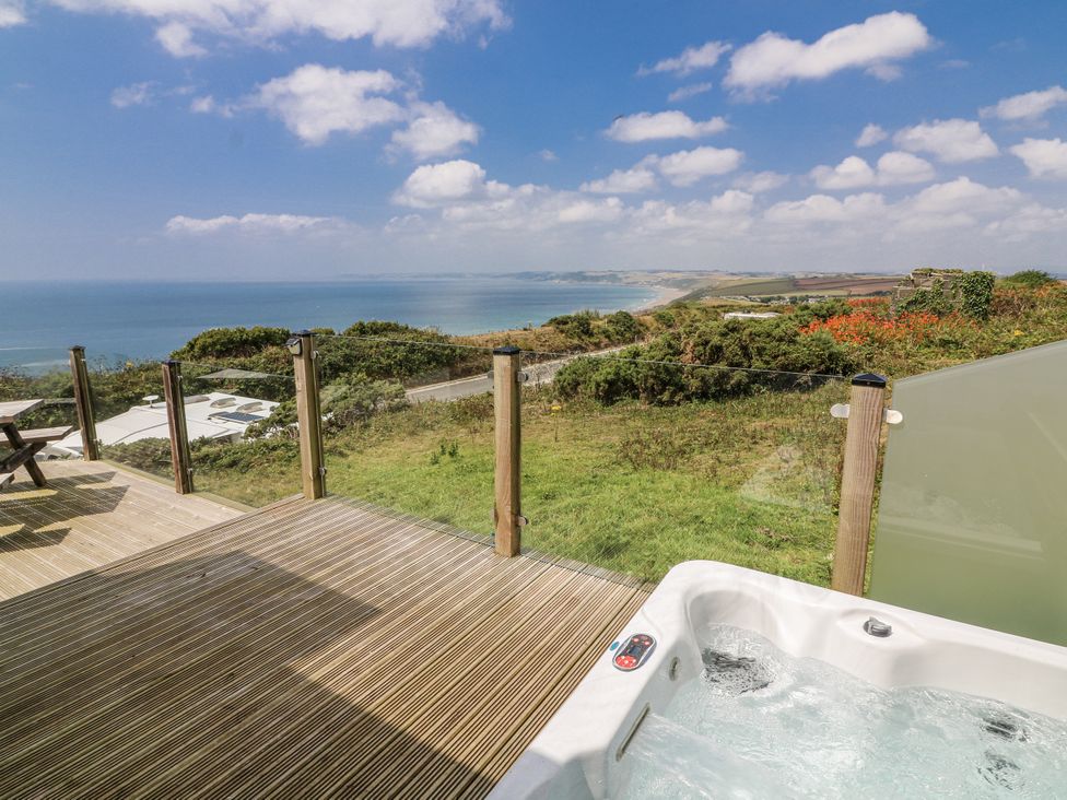 An outdoor area with a hot tub and ocean view at Sunset Sea View Chalet in Millbrook