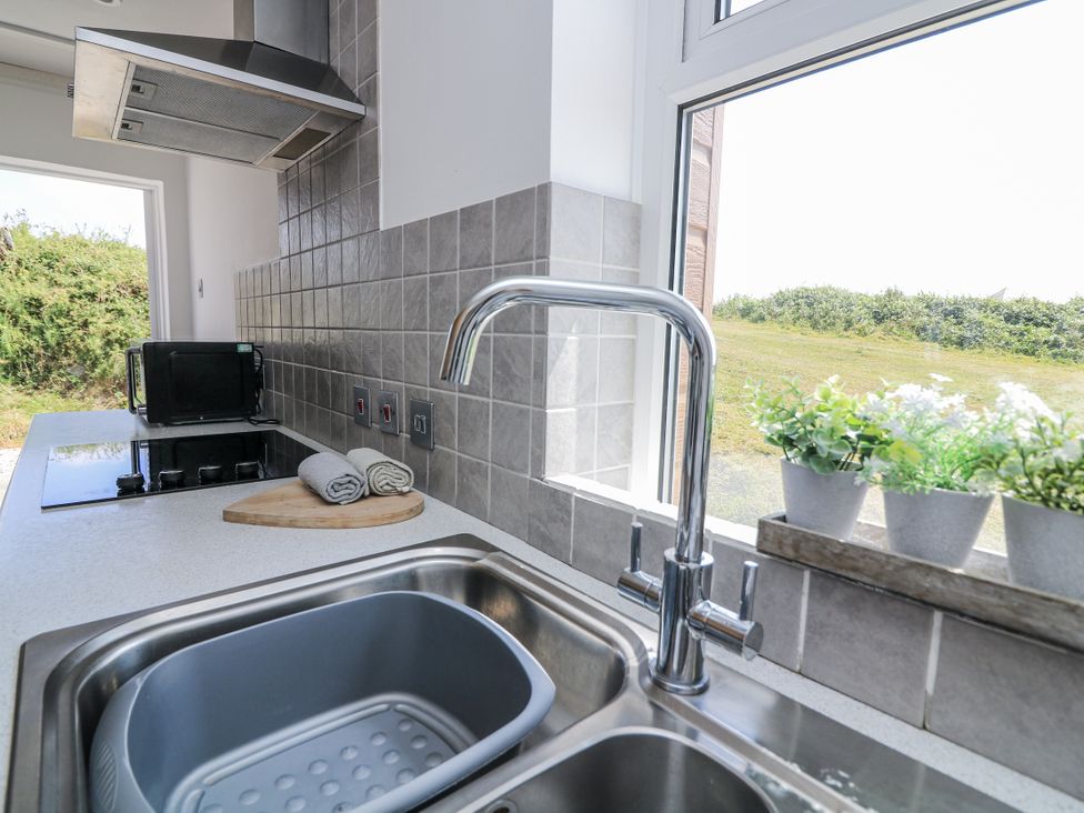 A kitchen with sink and stove at Sunset Sea View Chalet in Millbrook