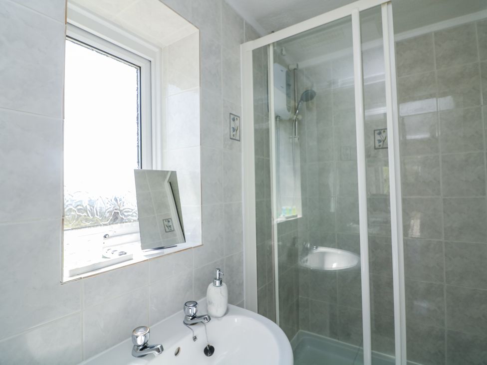 A bathroom with a sink and shower at Sunset Sea View Chalet in Millbrook