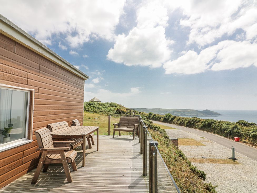 An outdoor deck with a table and chairs at Sunset Sea View Chalet in Millbrook