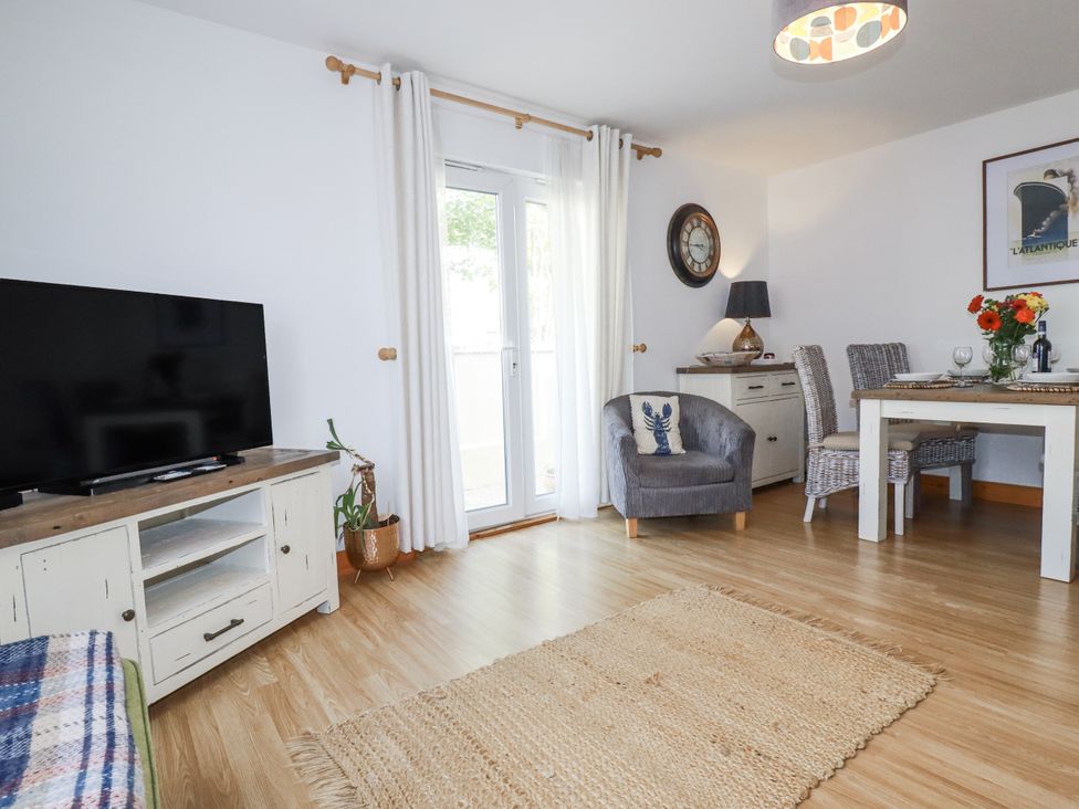 A living room with a television and dining area at Flat 4 in Newquay