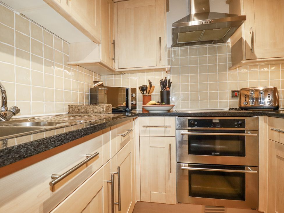 A kitchen with cabinets and appliances at Flat 4 in Newquay
