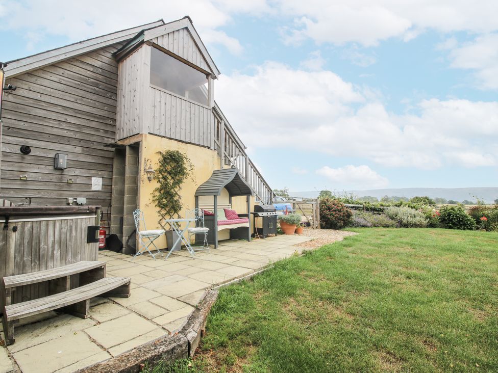 A garden with a hot tub and seating area at Stable Cottage in Norbury near Bishop's Castle