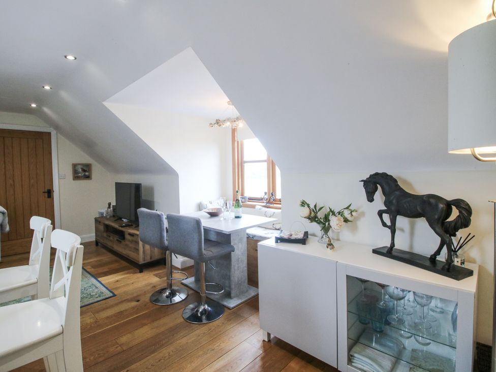 A living room with a television and horse statue at Stable Cottage Norbury near Bishop's Castle
