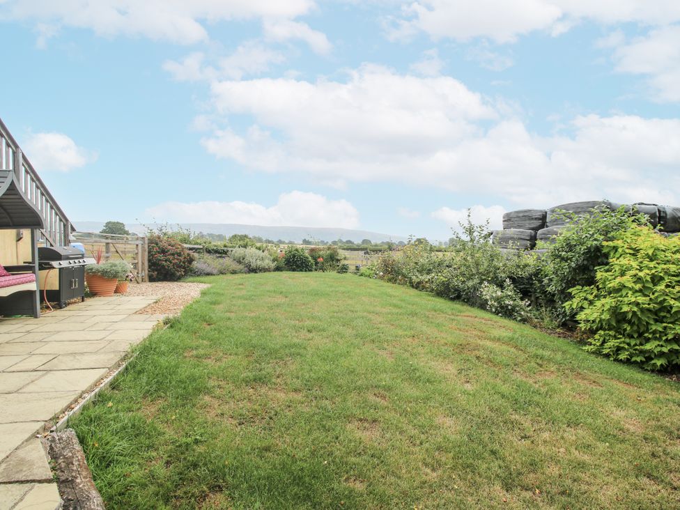 A garden with grass and patio area with a barbecue at Stable Cottage Norbury near Bishop's Castle