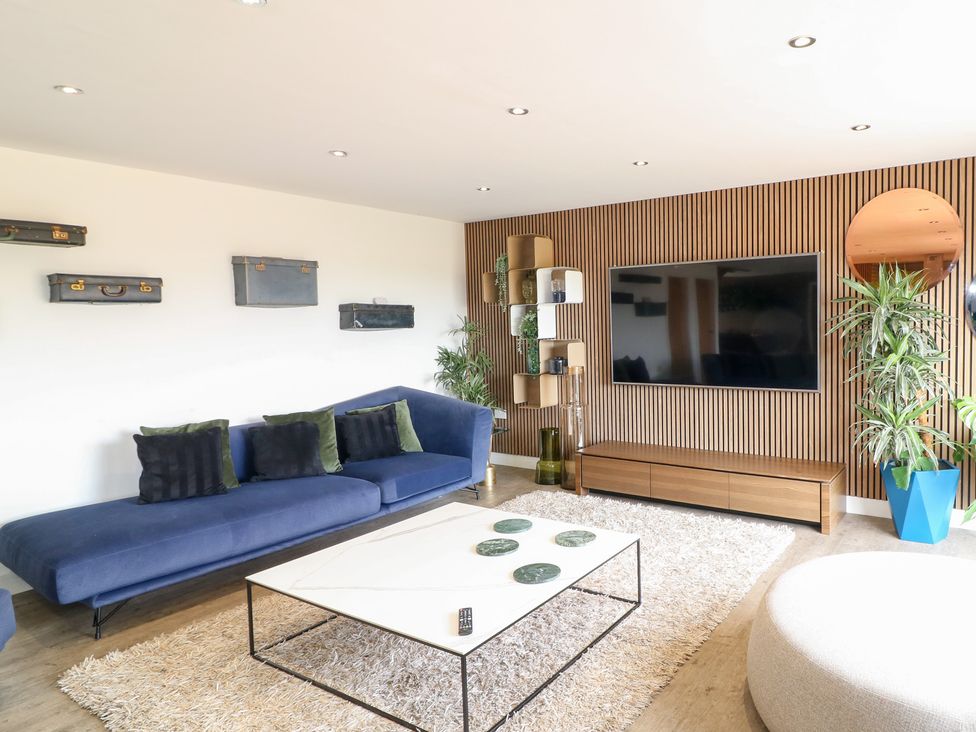A living room with a sofa and a television at Hideaway in Scampton