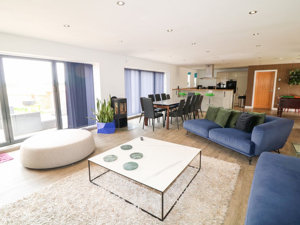 A living room with a sofa and dining area at Hideaway in Scampton